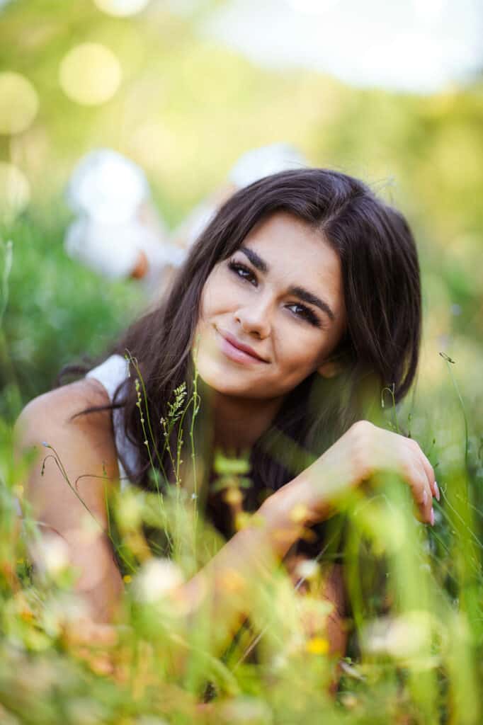 Beautiful young woman laying in the grass.