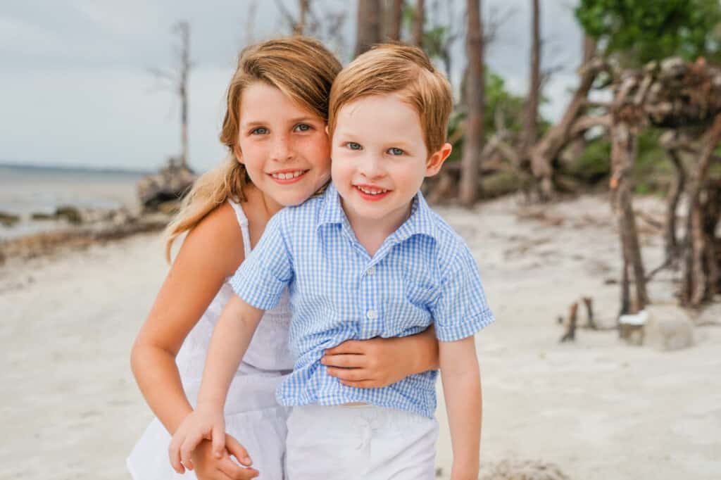 A boy and a girl hugging on the beach.