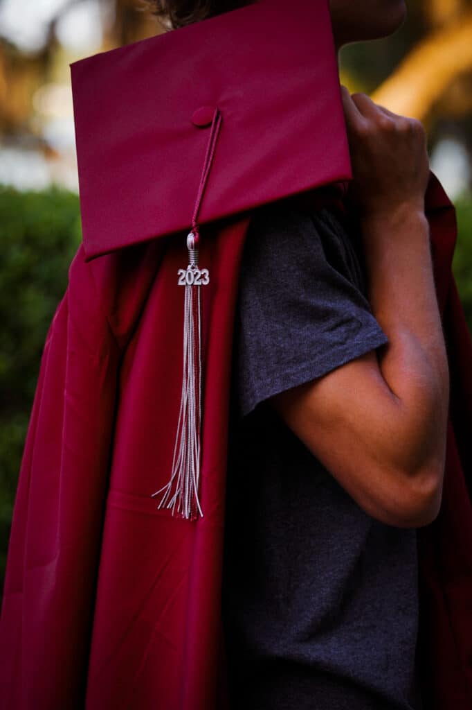 A person wearing a red graduation cap and tassel.